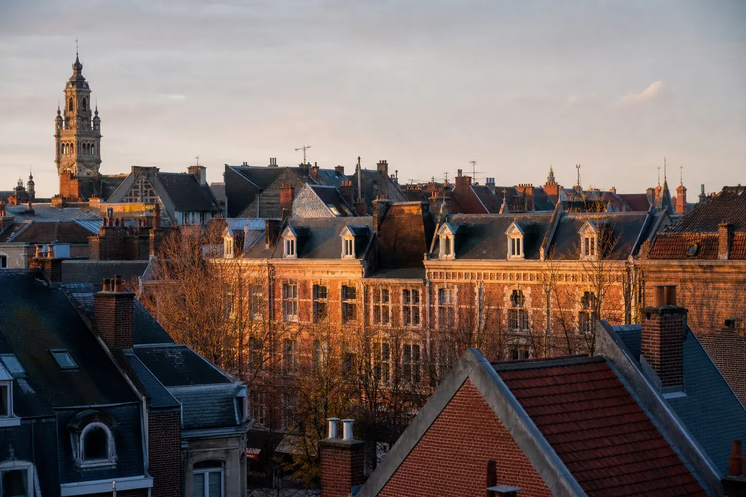 Vue urbaine discrète d’une architecture typique du nord de la France, façades de brique et toits caractéristiques